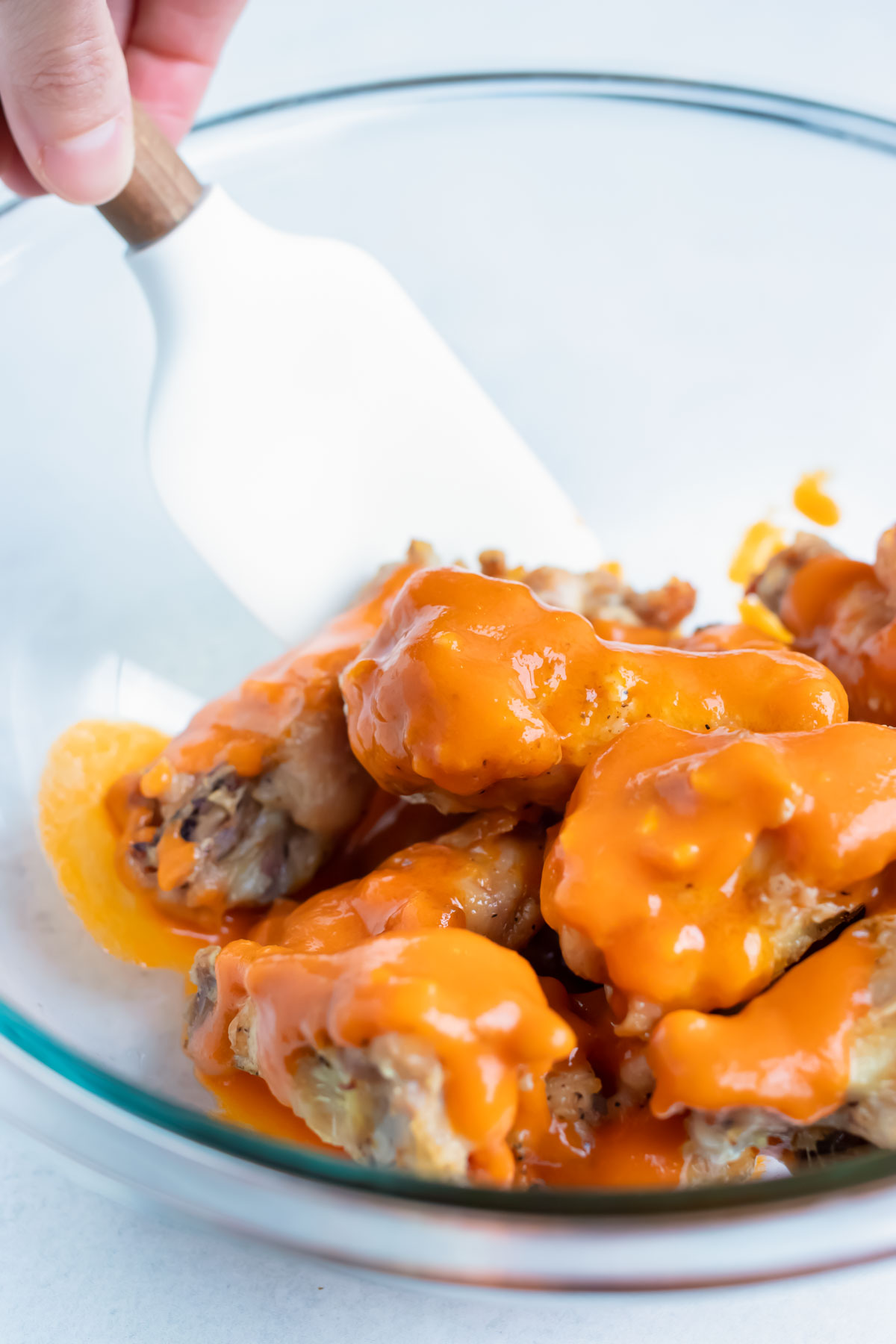 Baked wings are coated with a spicy buffalo sauce before baking.