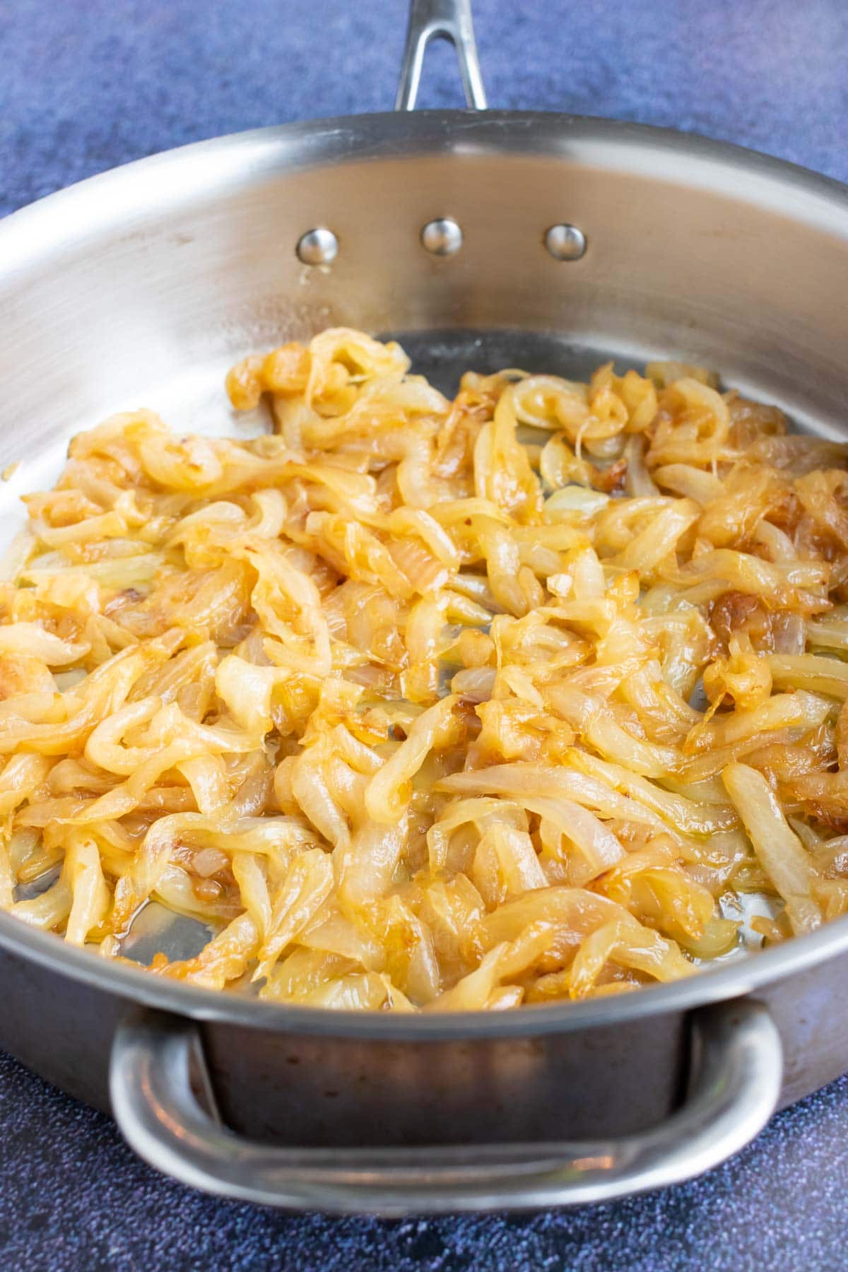 An image showing golden-brown sautéed onions in a skillet.