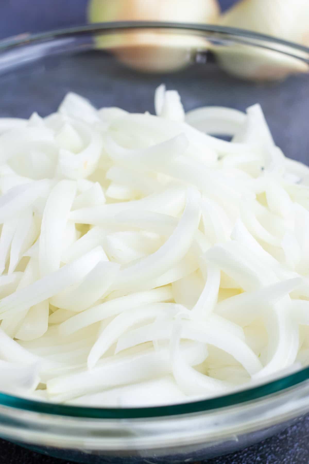 A bowl full of onions that are being separated for a sautéed onions recipe.