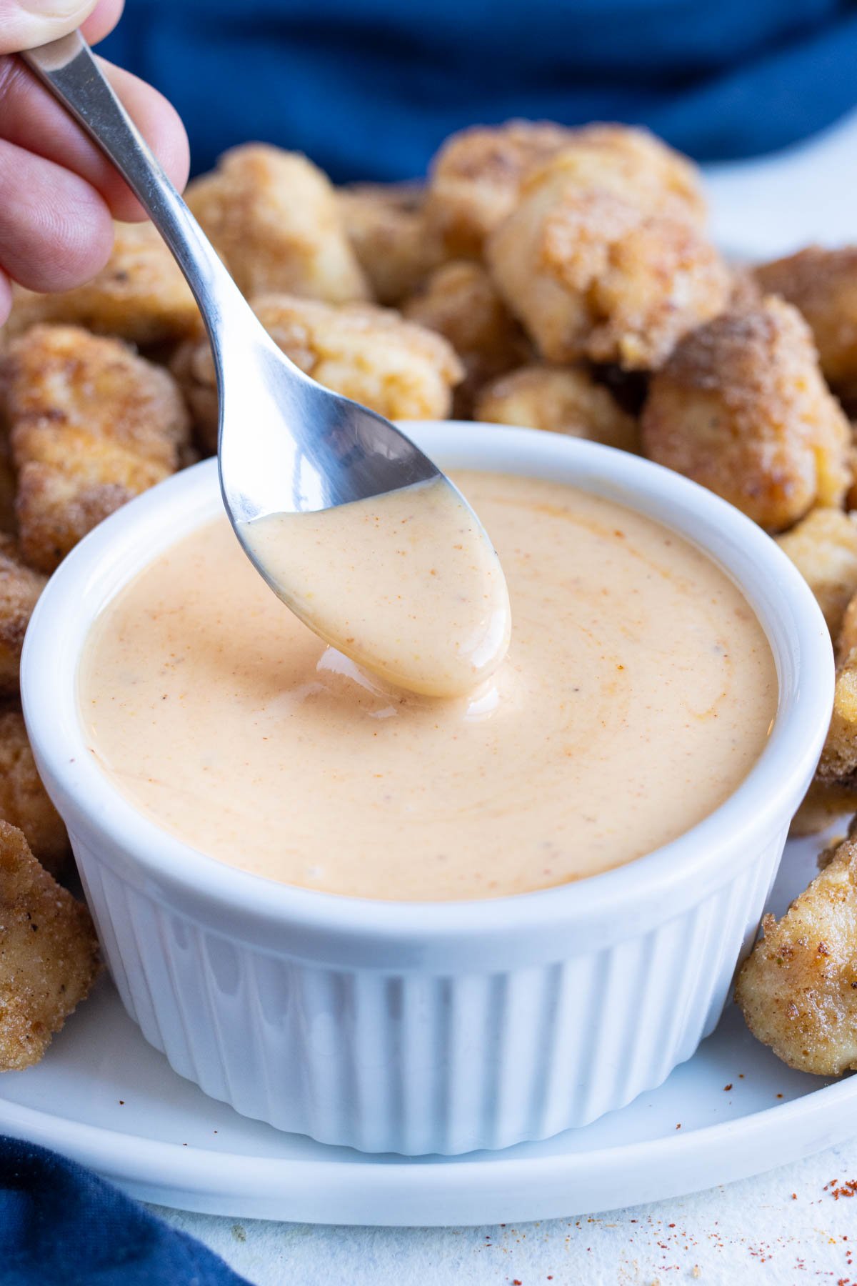 Sauce is scooped into a small white bowl.