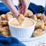 A chicken nugget is dipped in copycat Chick-fil-A sauce.