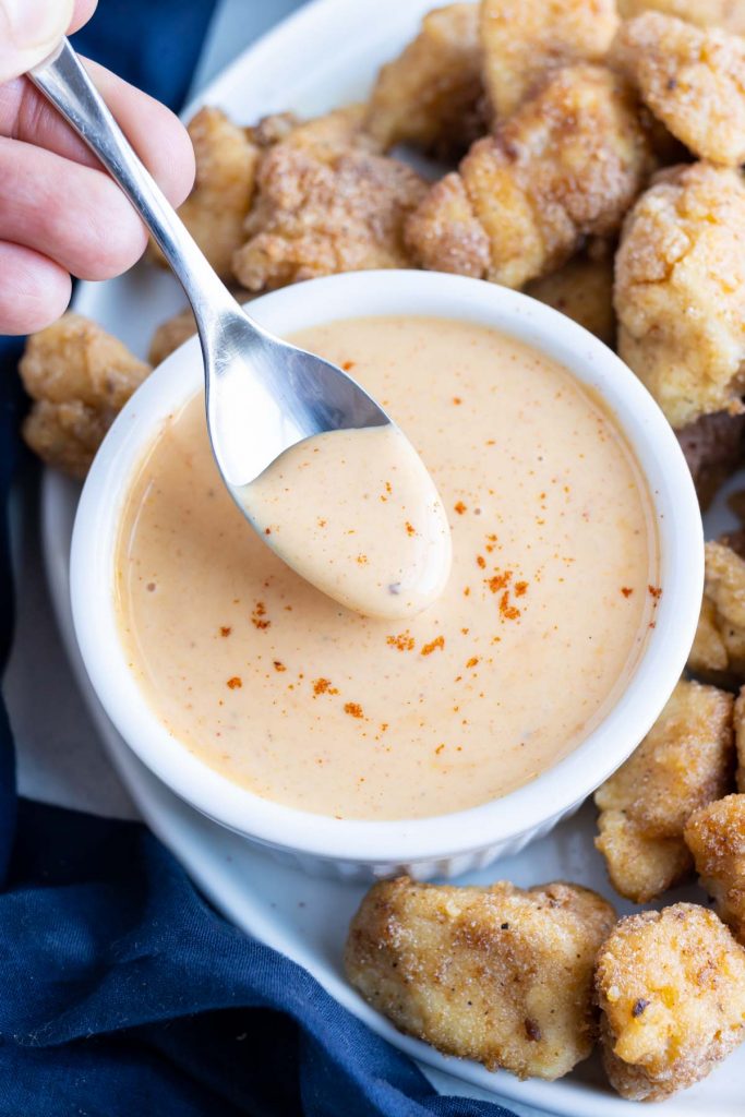 Copycat Chick-fil-A sauce is shown in a small white bowl with nuggets.