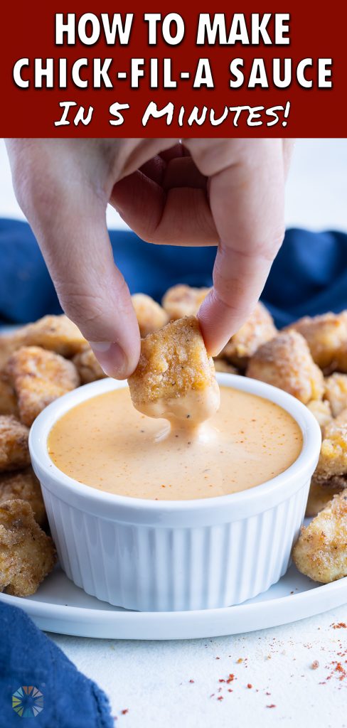 A chicken nugget is dipped into the Chick-fil-A sauce.