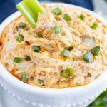 A bowl of low-carb buffalo chicken dip is eaten with celery.