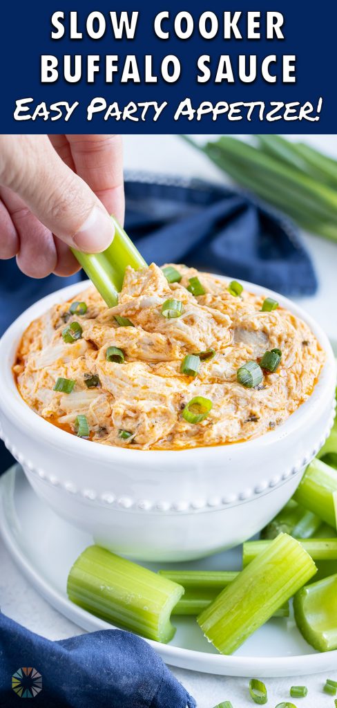 Buffalo chicken dip is set on a plate with cut celery.