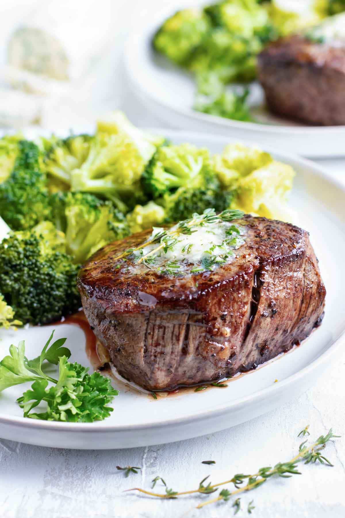 The best filet mignon recipe on a white plate with broccoli.