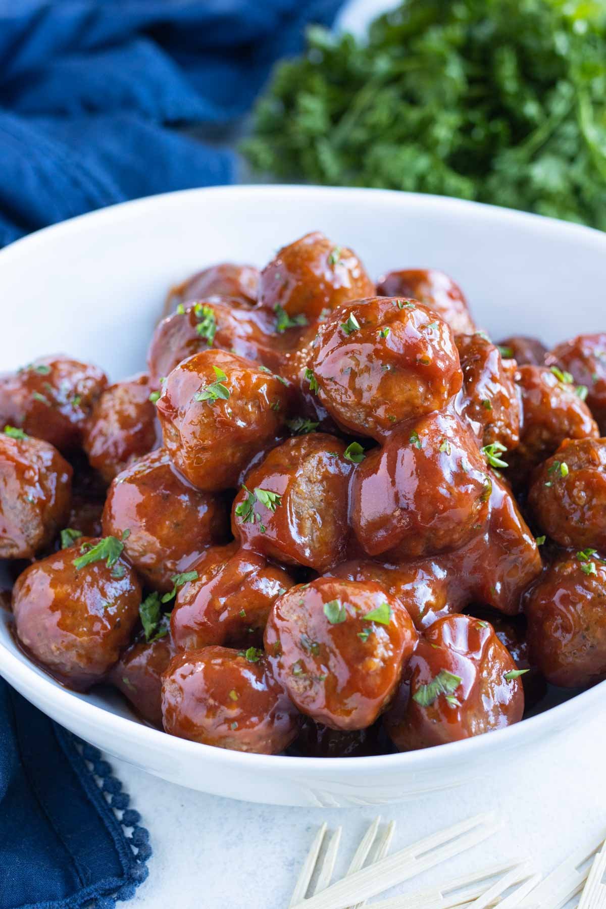 Meatballs are served in a white bowl on the table.