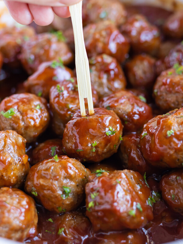 Grape jelly meatballs are cooked in a Crockpot and served with toothpicks.