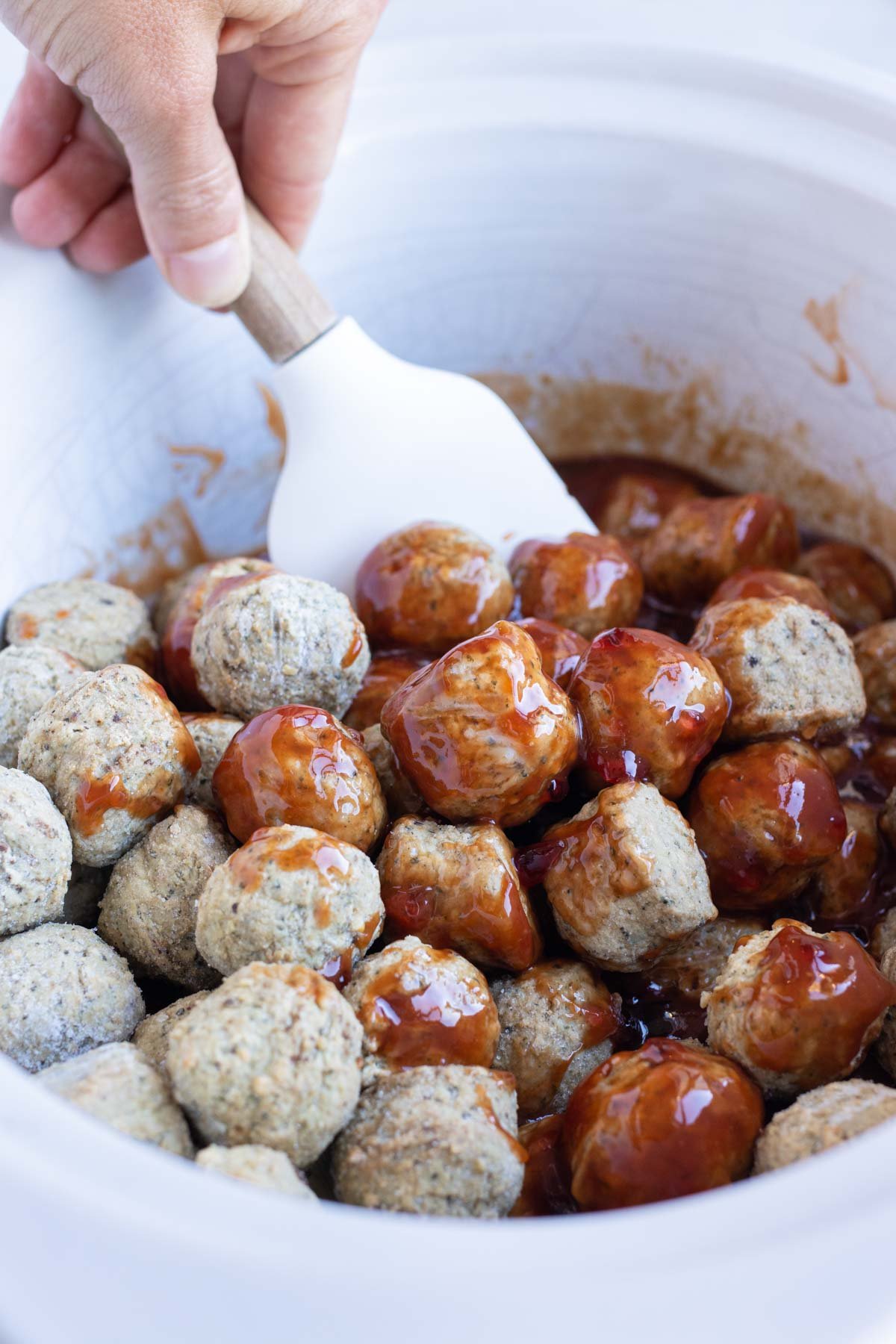 Meatballs are added to the slow cooker.