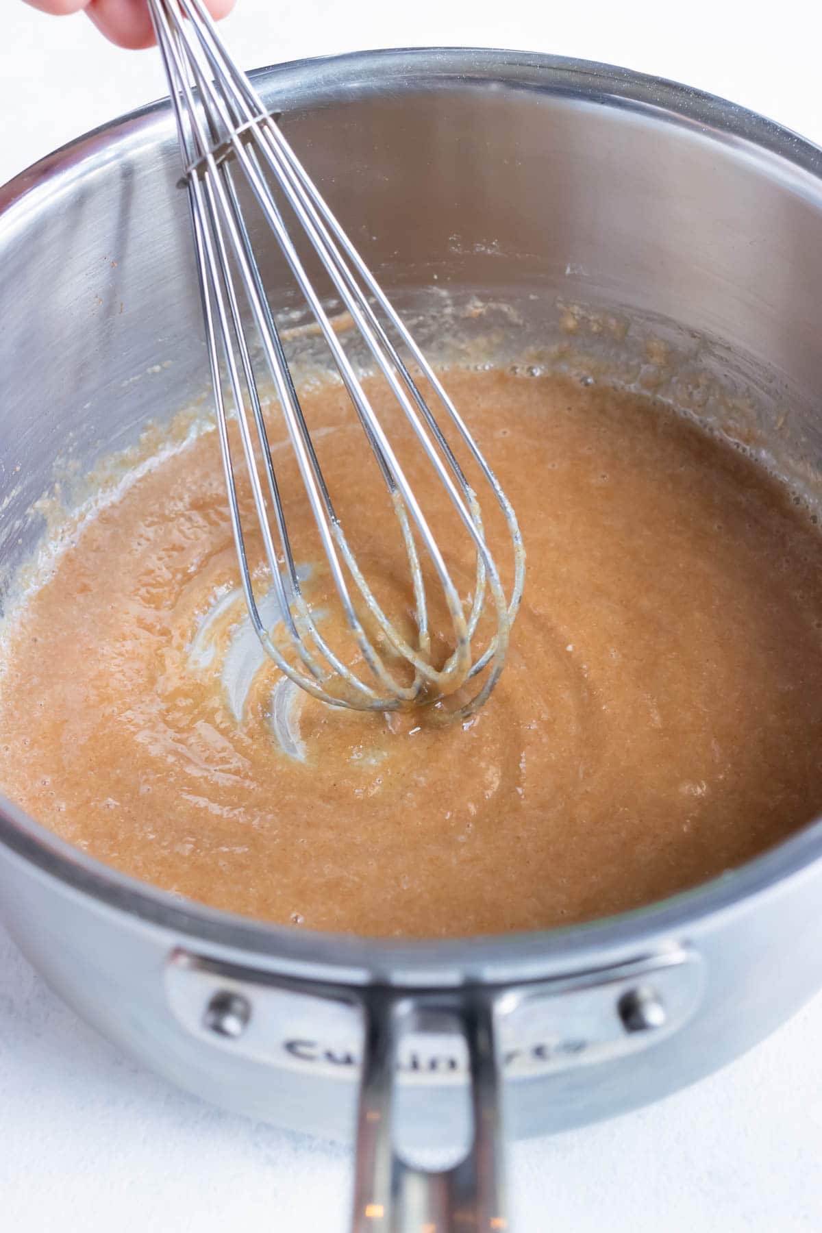 This light brown roux is whisked on the stove.