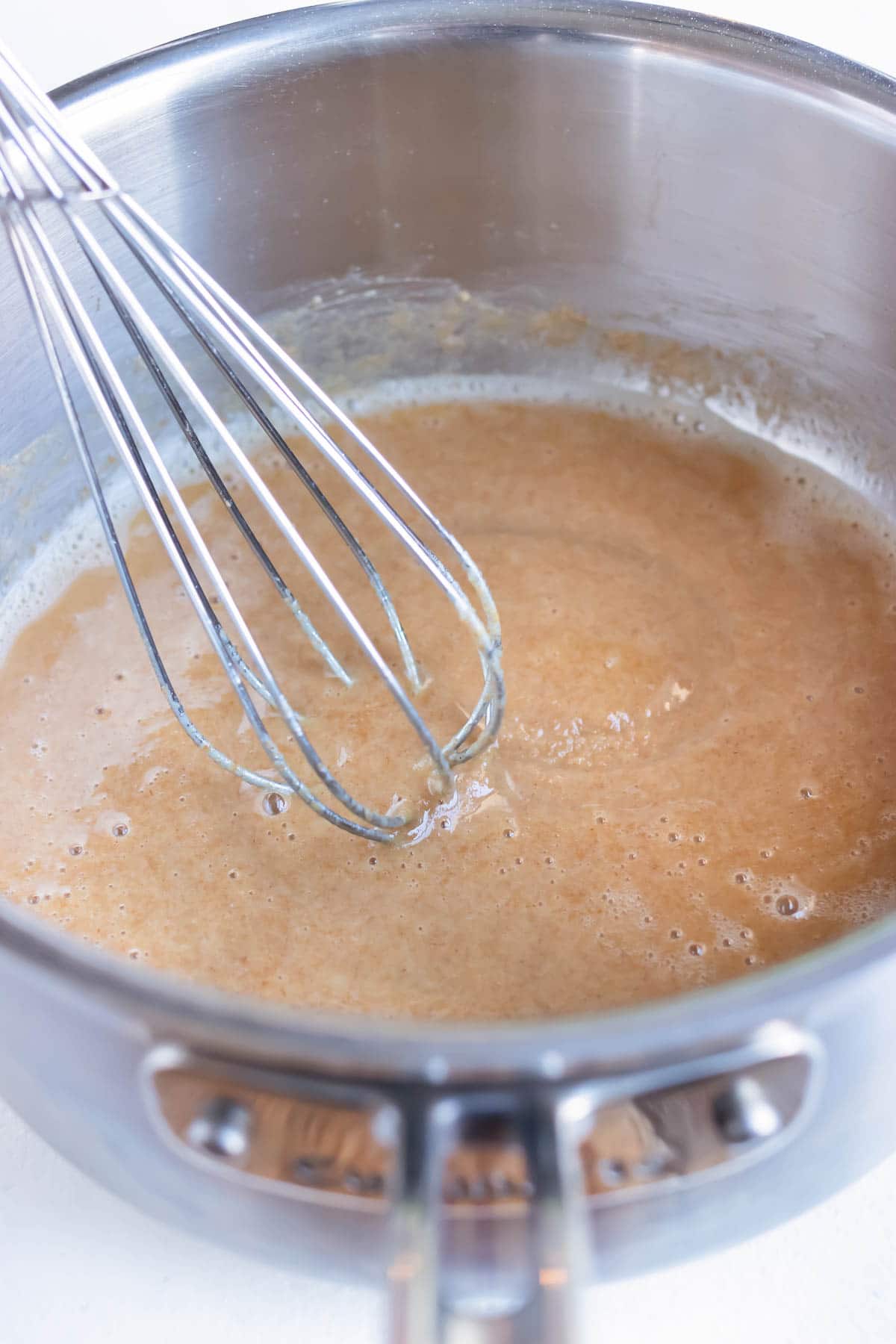 The roux ingredients are allowed to simmer while whisking throughout the cooking time.