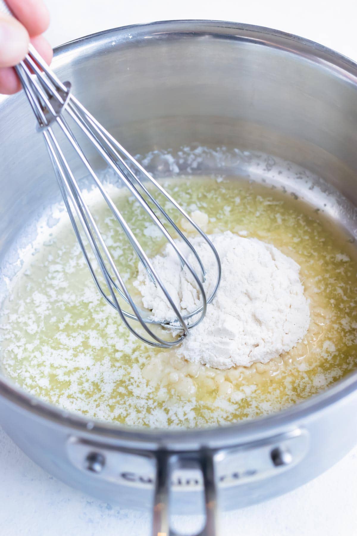 Flour and melted butter are mixed with a whisk.