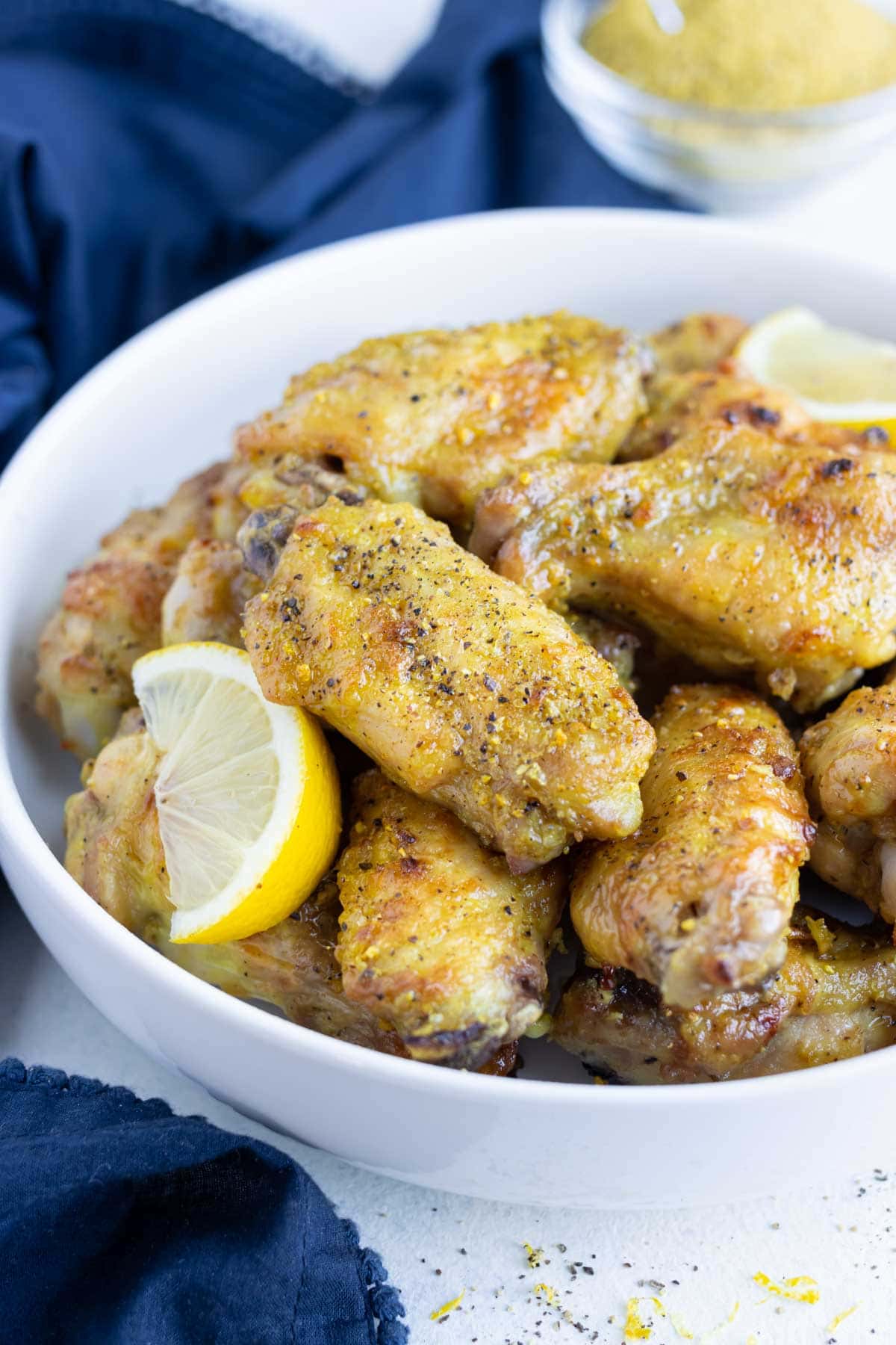 Oven-baked lemon pepper wings are served as a low-carb appetizer in a bowl.