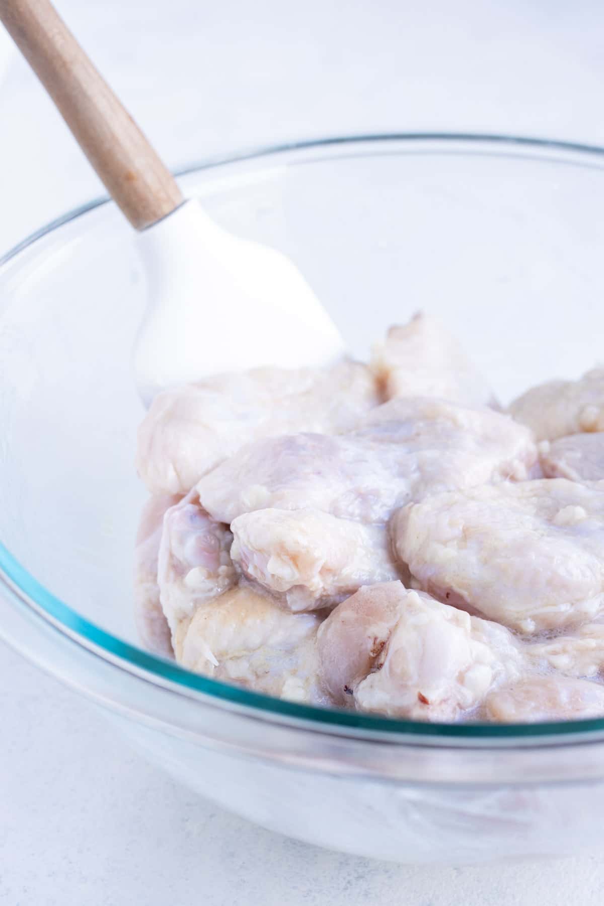 Raw wings and drumsticks are tossed in the seasoning and oil.