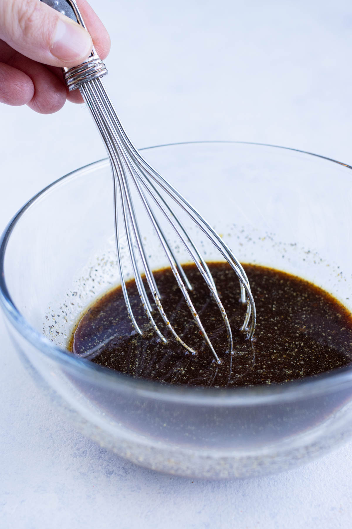 Sauce ingredients are mixed together in a bowl with a whisk.