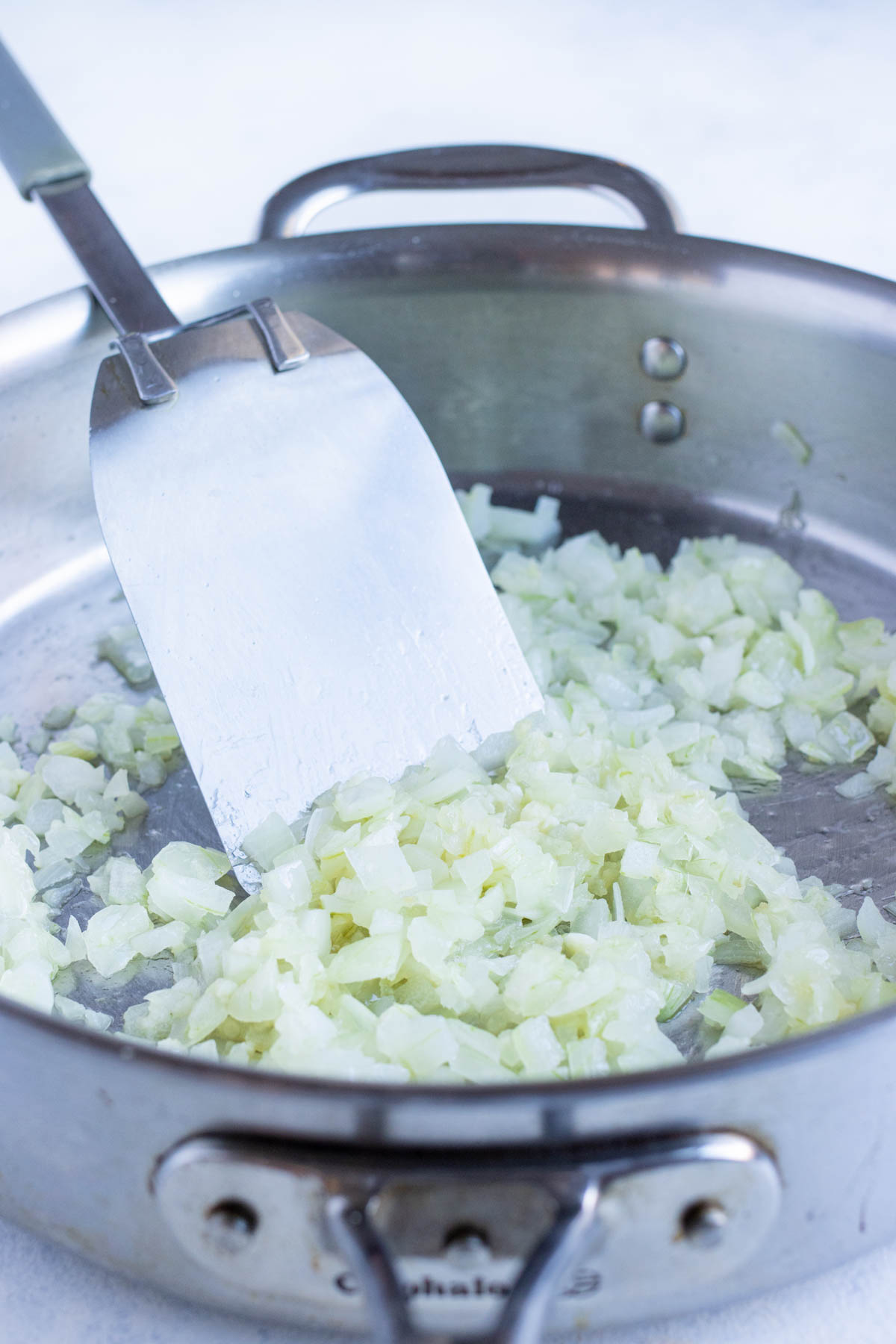 Diced onions are sautéed in a skillet.
