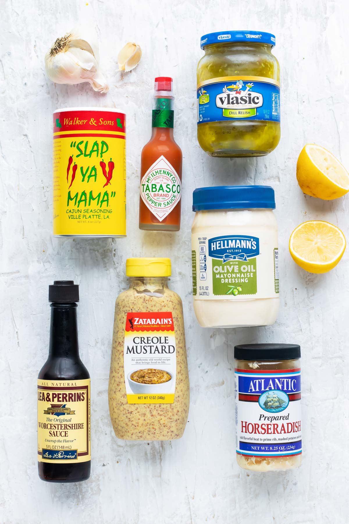 The ingredients for a Cajun remoulade sauce including mayonnaise, mustard, lemon juice, paprika, Cajun seasoning, and horseradish.