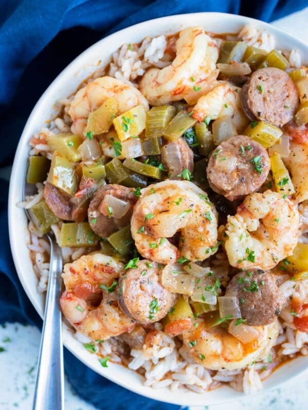 Loaded shrimp and sausage gumbo is eaten from a bowl with a spoon.