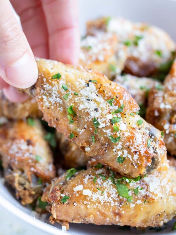 Crispy Garlic Parmesan Chicken Wings are in a serving bowl for a game day appetizer.