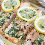 A close-up image of a lemon basil baked salmon recipe that has been baked in foil packets.