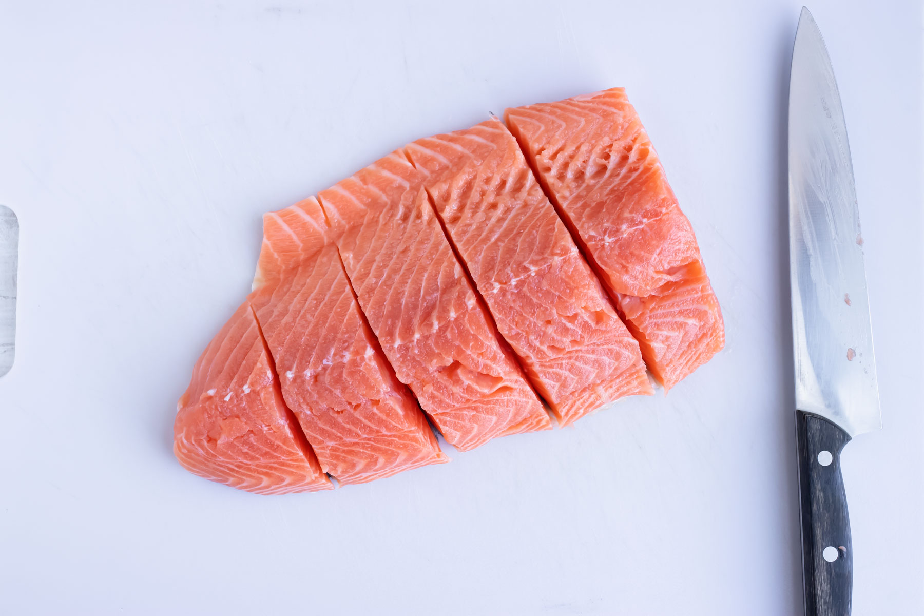 A pound of salmon cut into fillets.