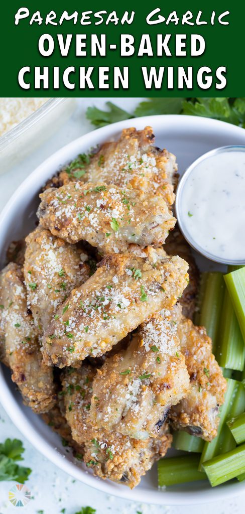 Crispy oven-baked chicken wings are served on a white plate with ranch.