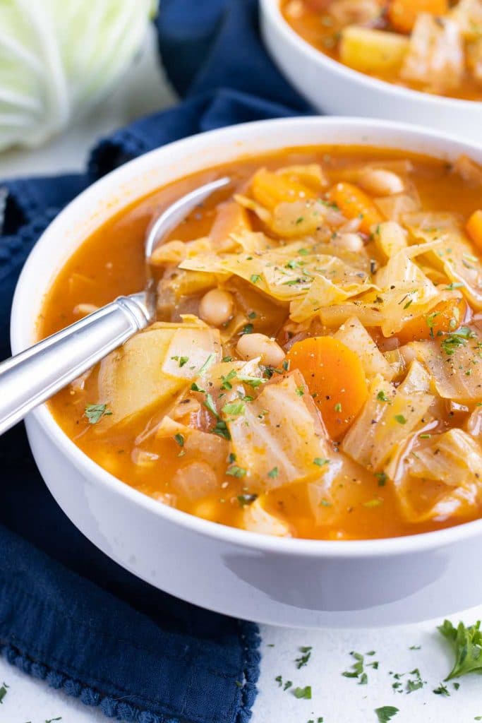 A bowl of cabbage soup with potatoes and tender cabbage for a vegetarian dinner.