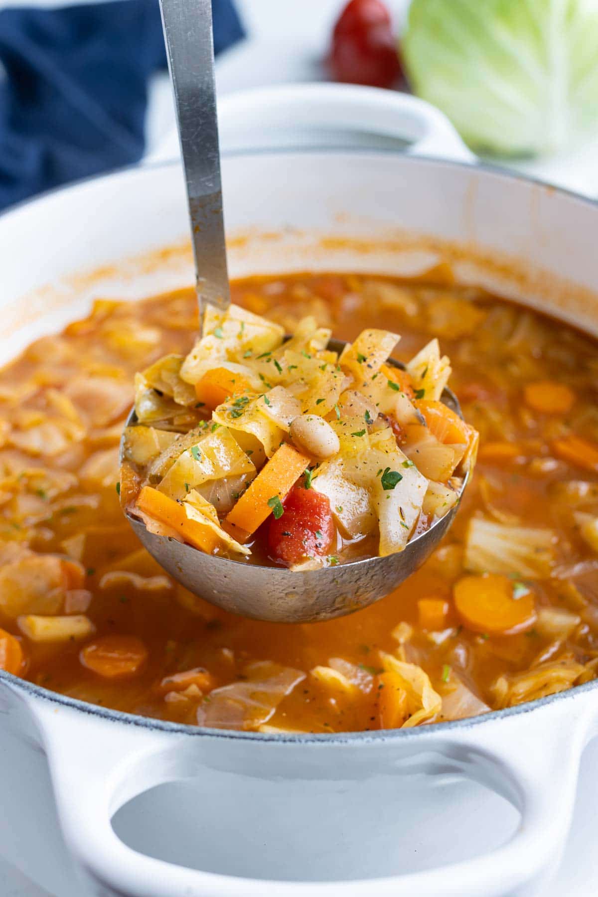 A ladle full of cabbage soup is served for a healthy vegan dinner.