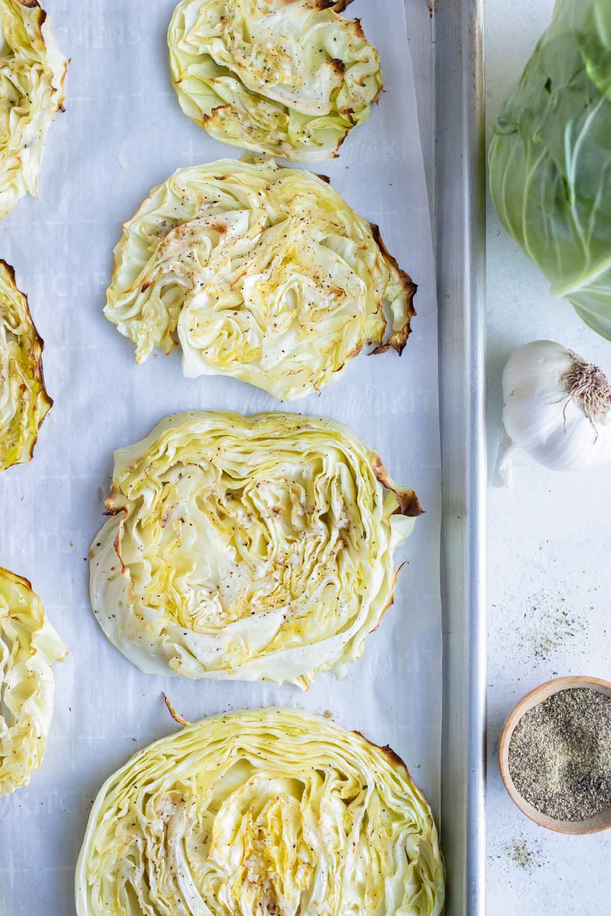 Low-carb cabbage steaks are roasted in the oven on a baking sheet.