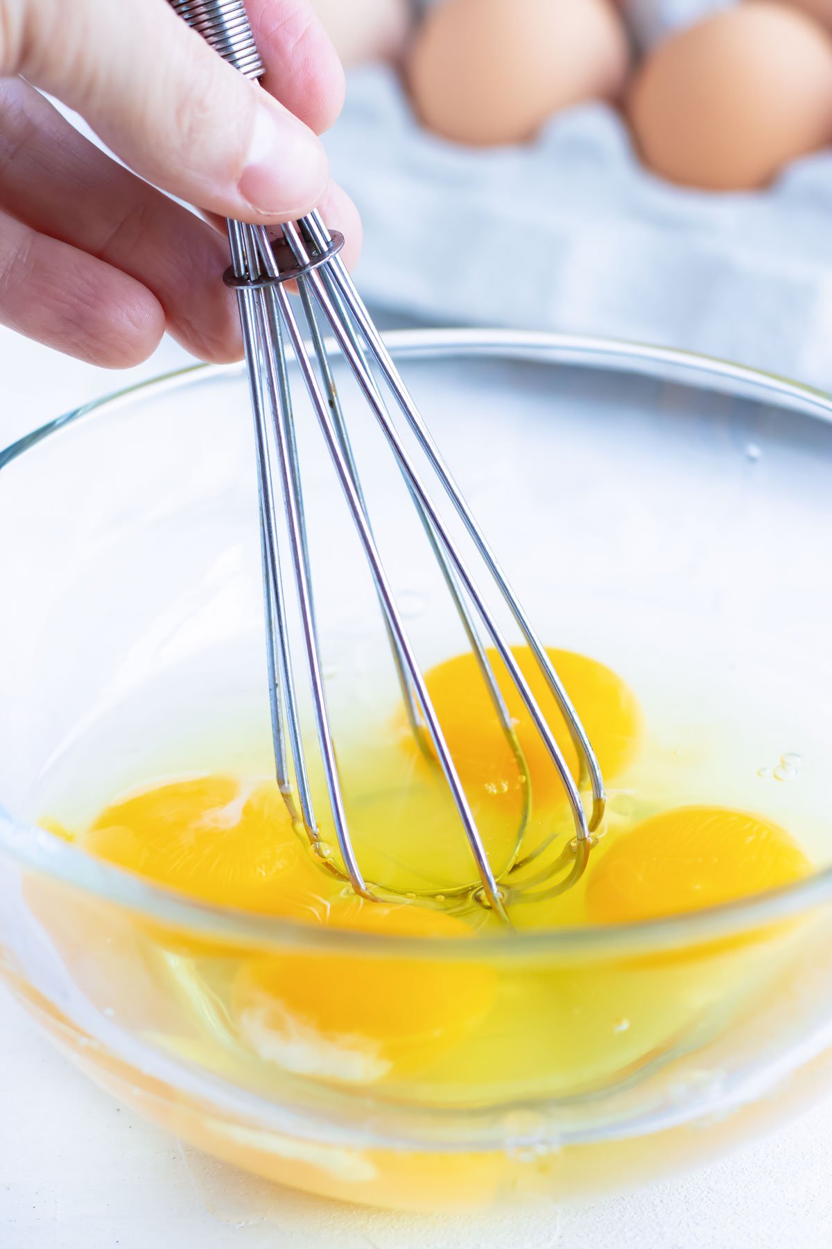 Eggs being whisked together to add to a chicken stir-fry with rice.