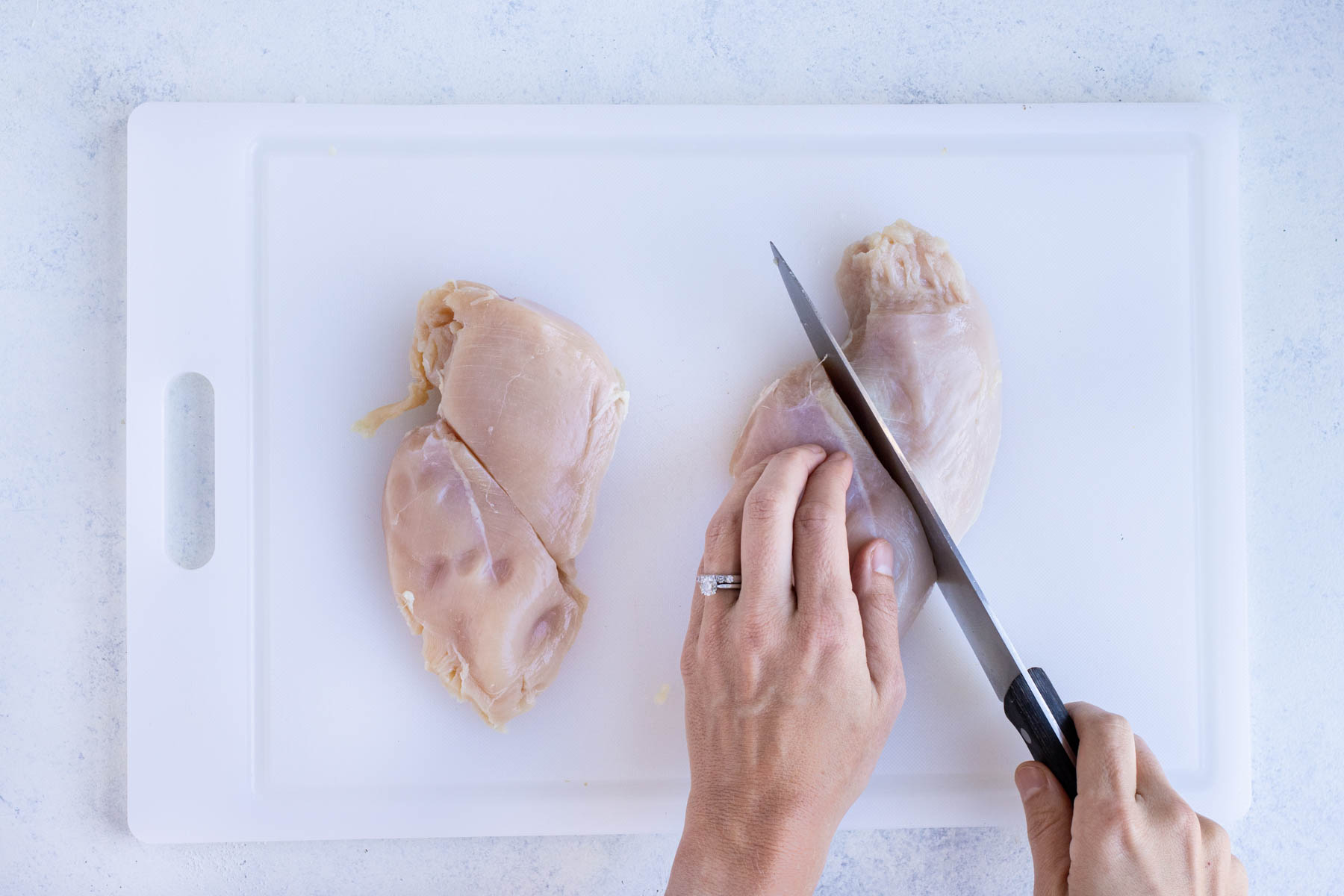 Two chicken breasts are cut in half.