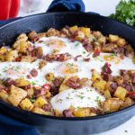 Corned beef hash is shown in a cast-iron skillet.