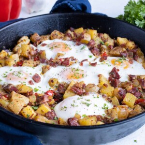 Corned beef hash is shown in a cast-iron skillet.