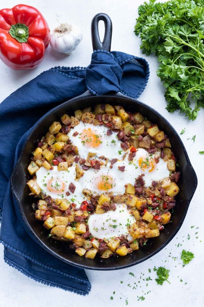 An overhead pictures shows a skillet full of corned beef hash and eggs.