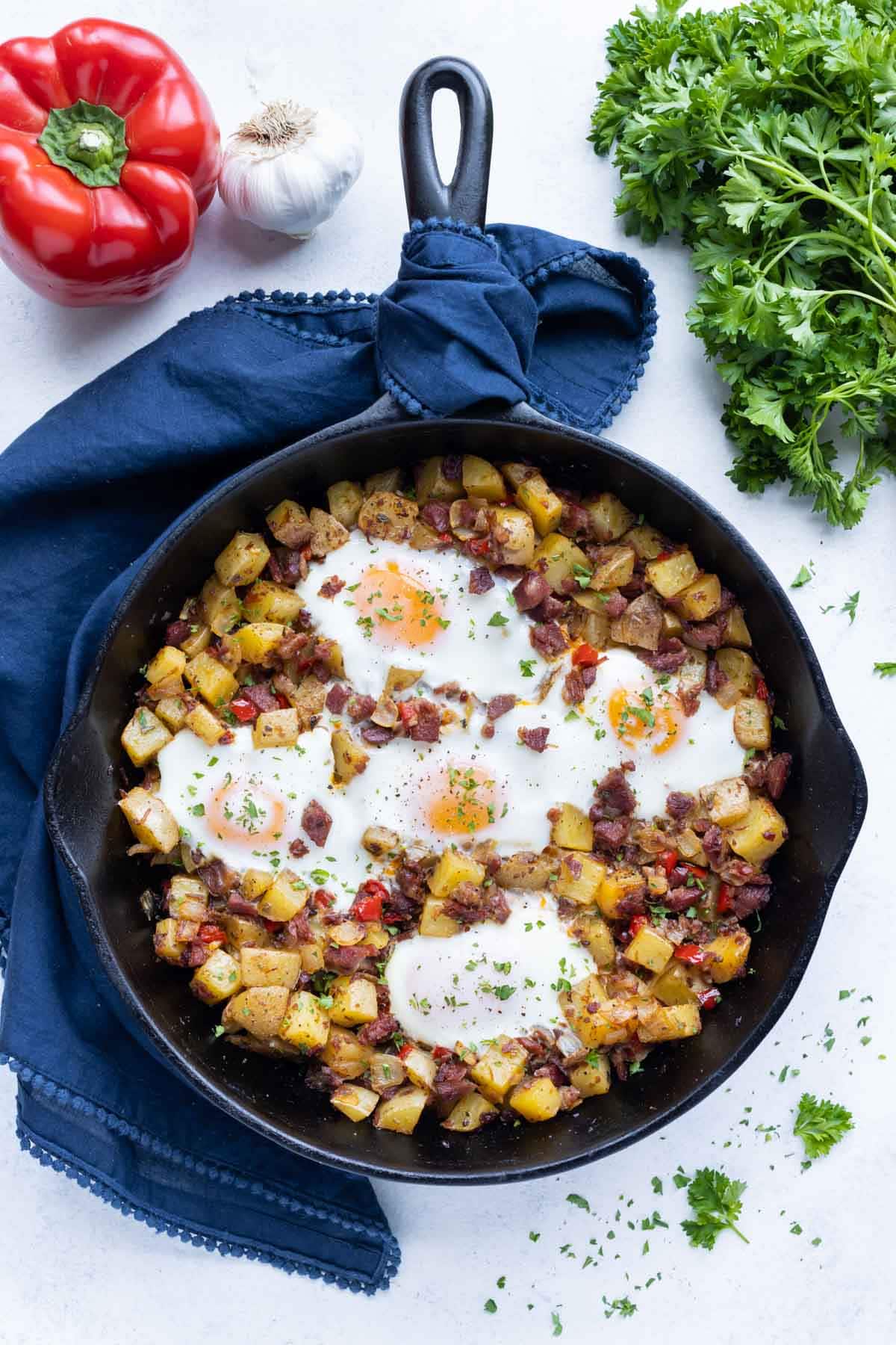 An overhead pictures shows a skillet full of corned beef hash and eggs.