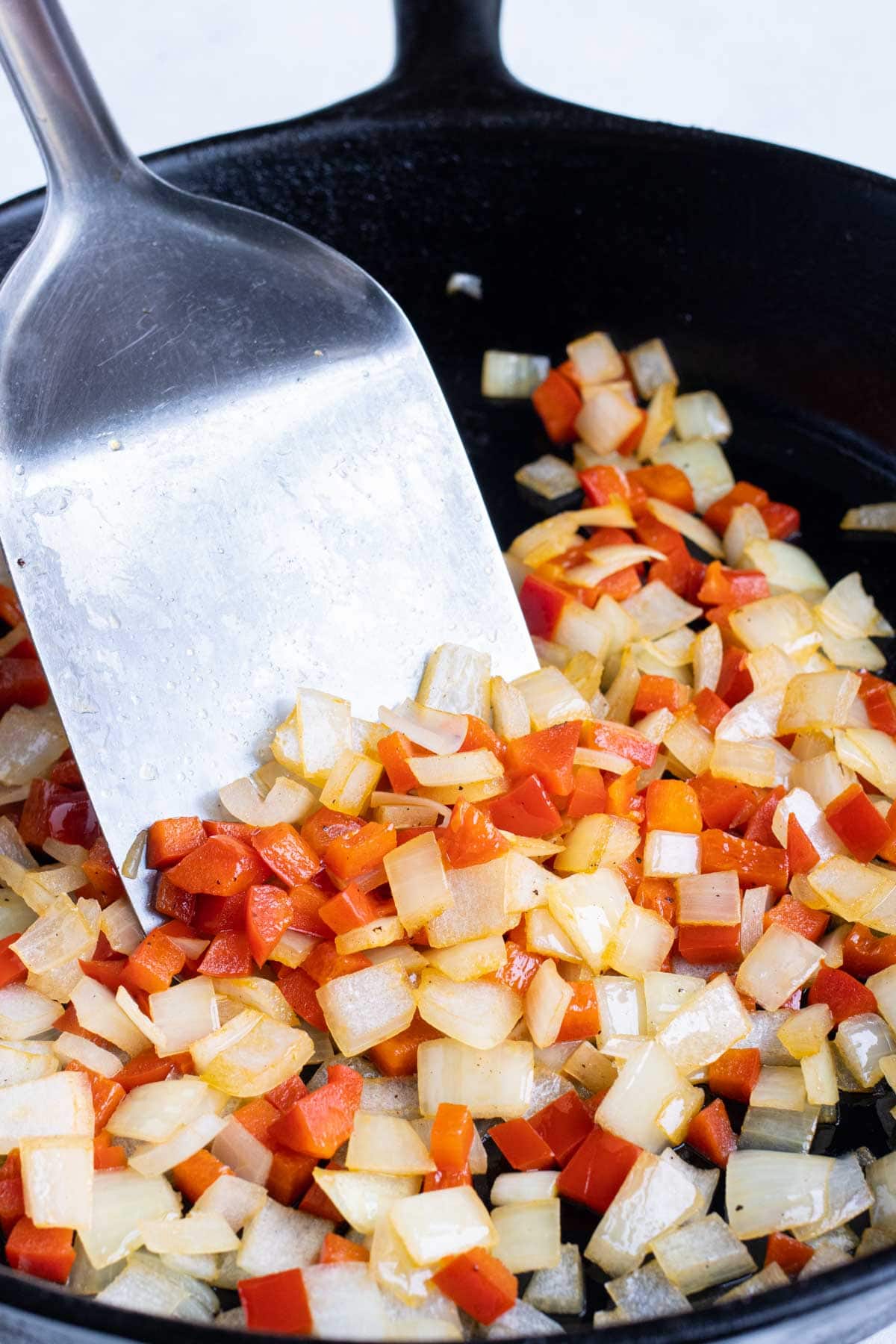 Bell peppers and onion are sautéed in the cast-iron skillet.