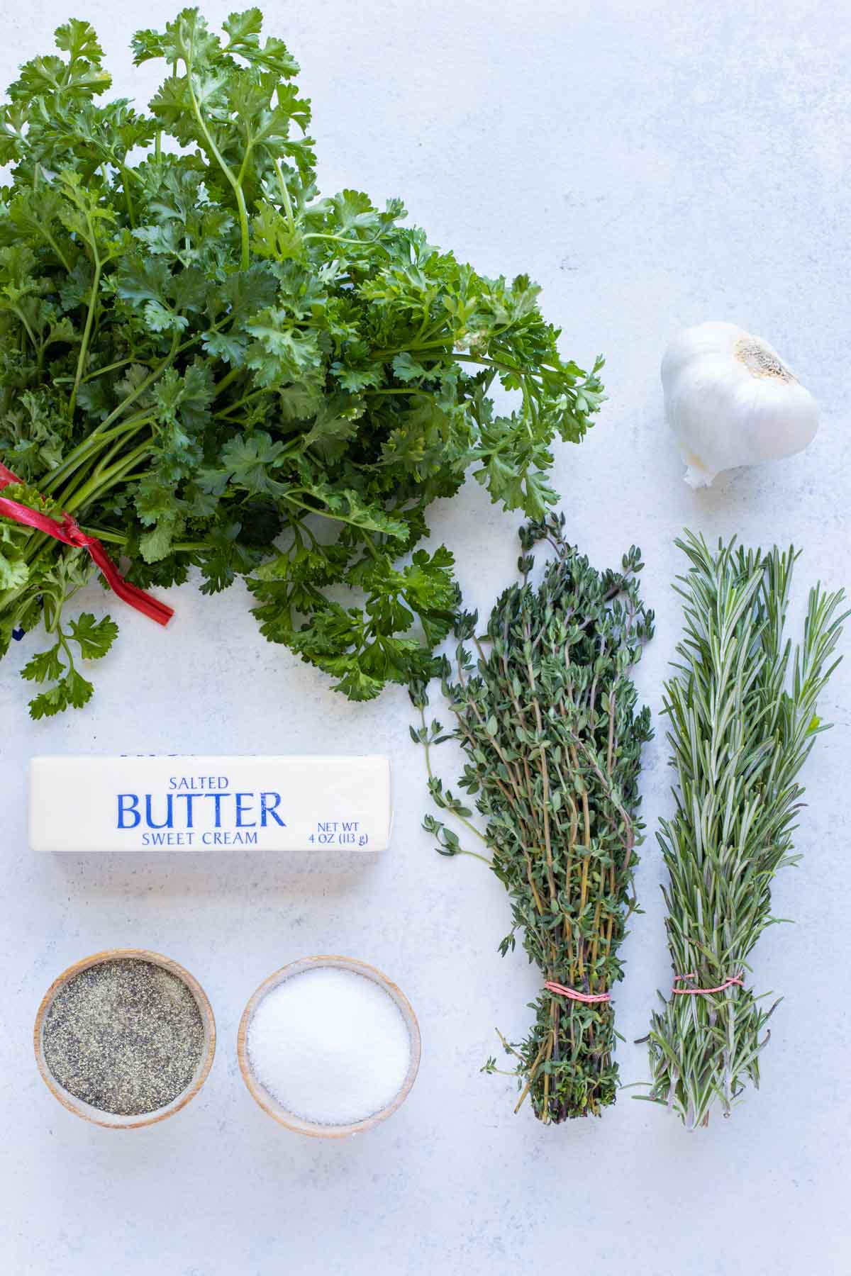 Butter, rosemary, thyme, parsley, garlic, salt, and pepper are the ingredients for this recipe.