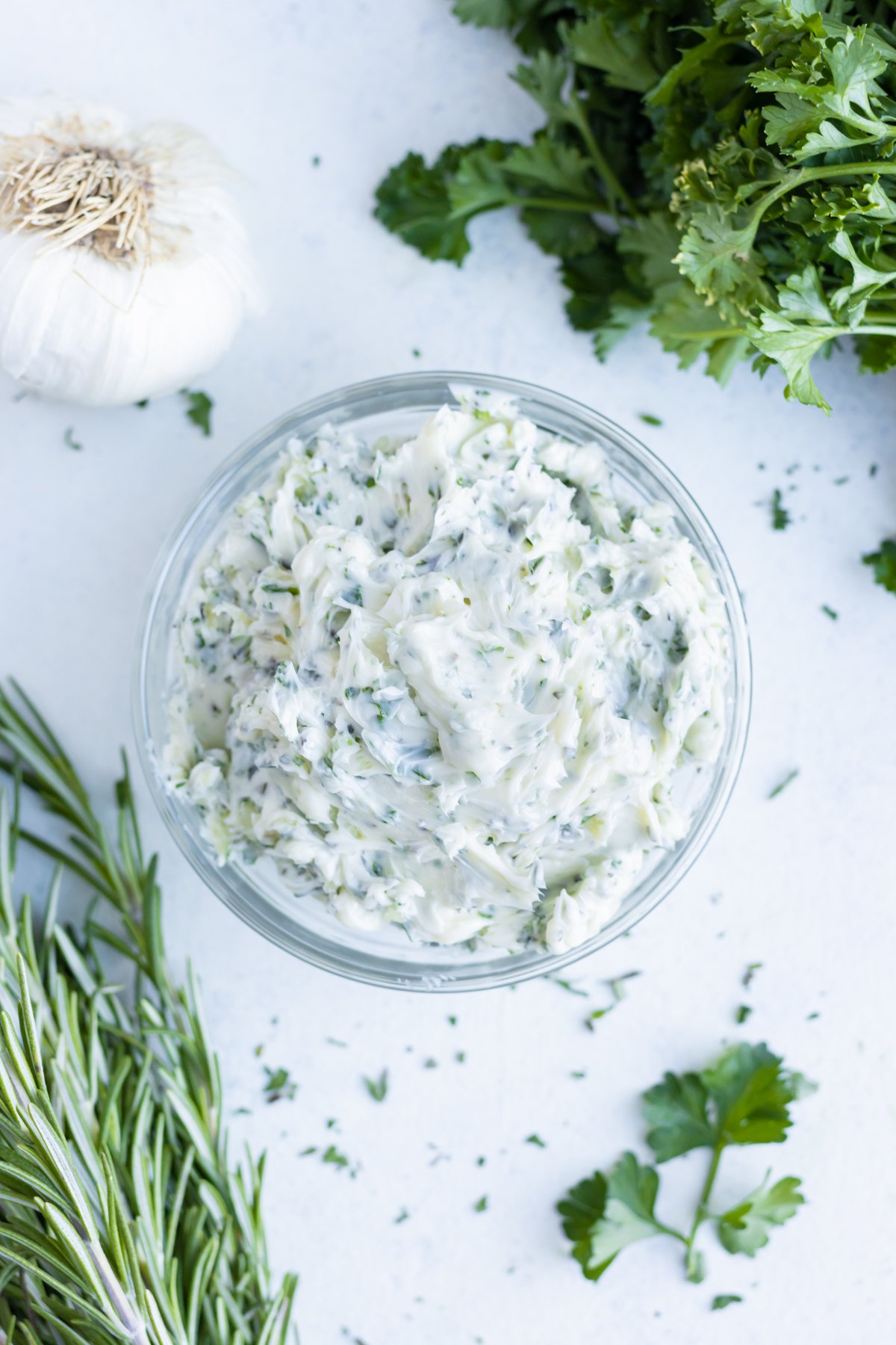 A glass bowl is filled with fresh herb butter.