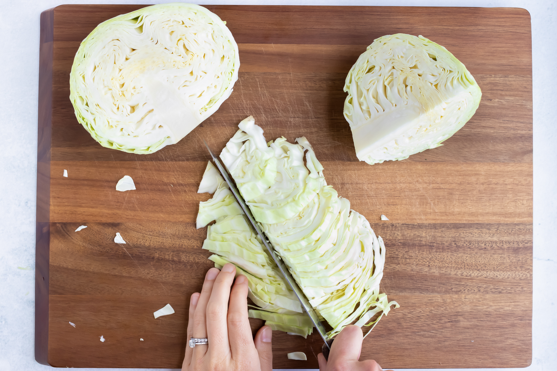 A knife cutting cabbage into thin 1-inch pieces.
