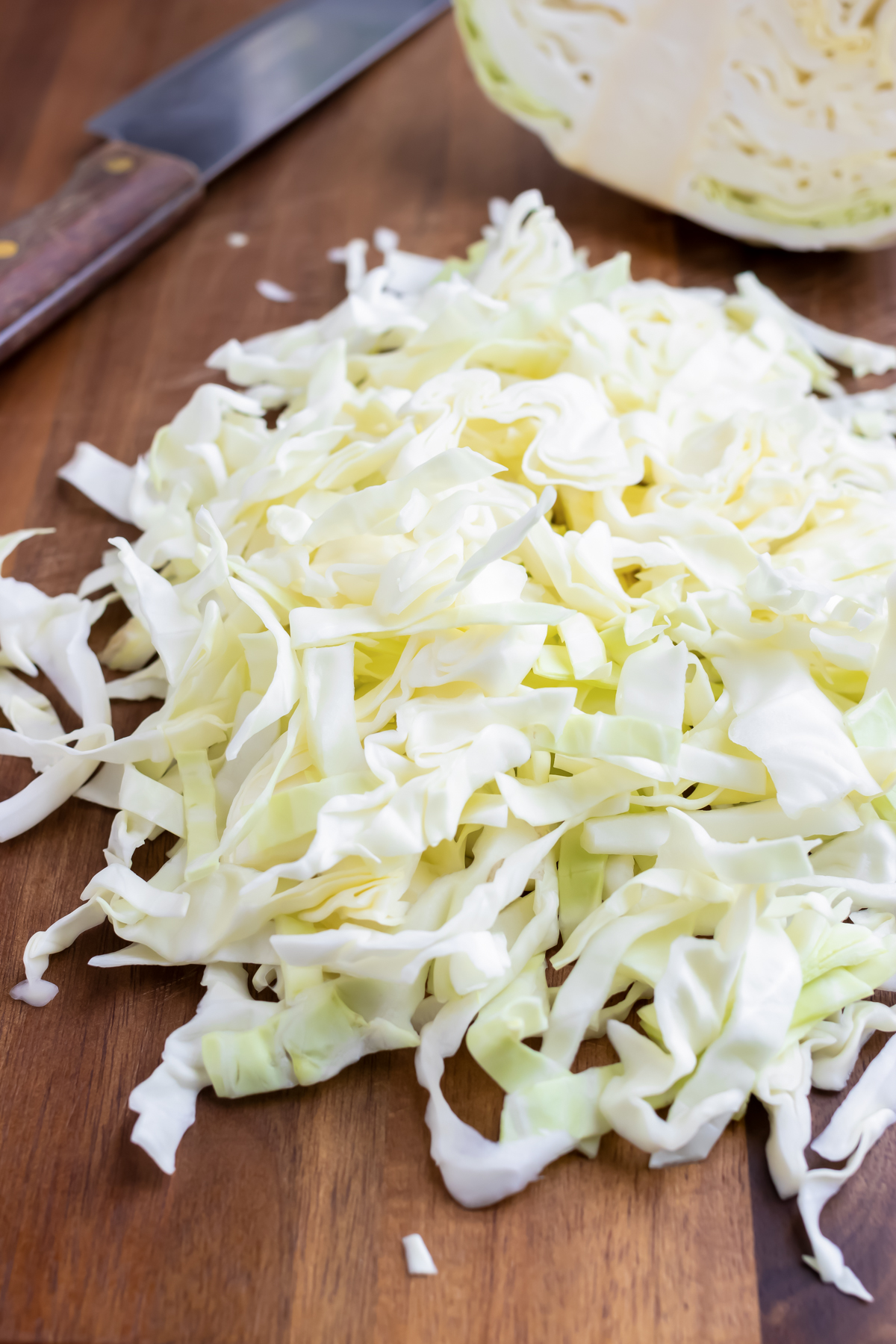 Fully shredded cabbage on a cutting board.