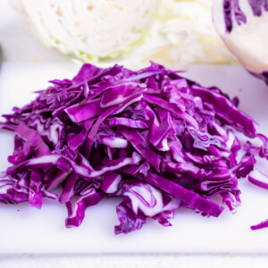 Shredded red cabbage on a cutting board.