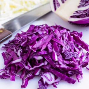 Shredded red cabbage on a cutting board.