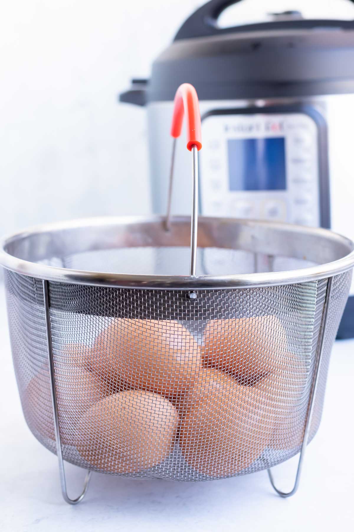 A steamer basket filled with eggs to make hard-boiled eggs.