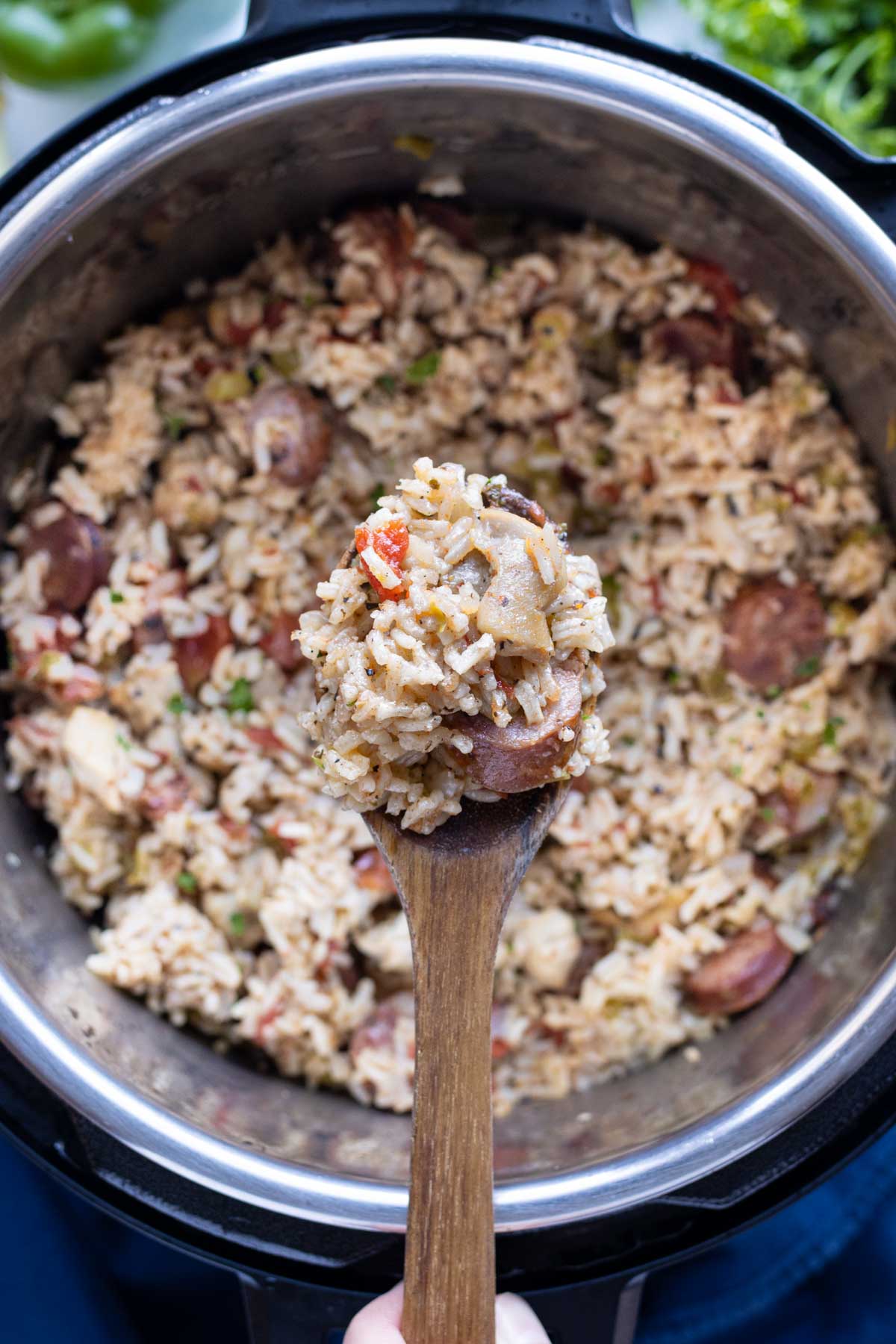 A wooden spoon is used to scoop out the jambalaya.