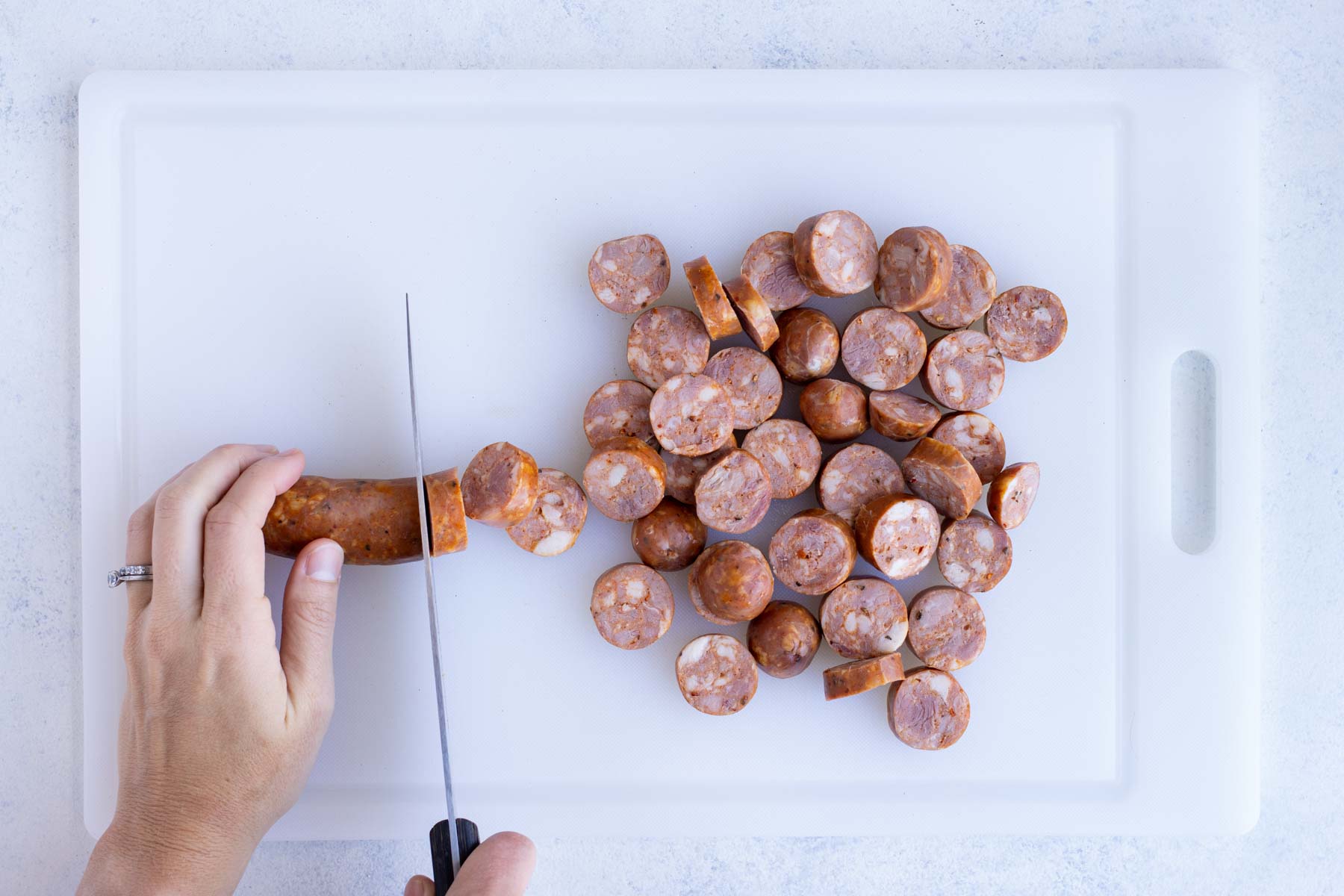 Sausage is cut into pieces on a cutting board.