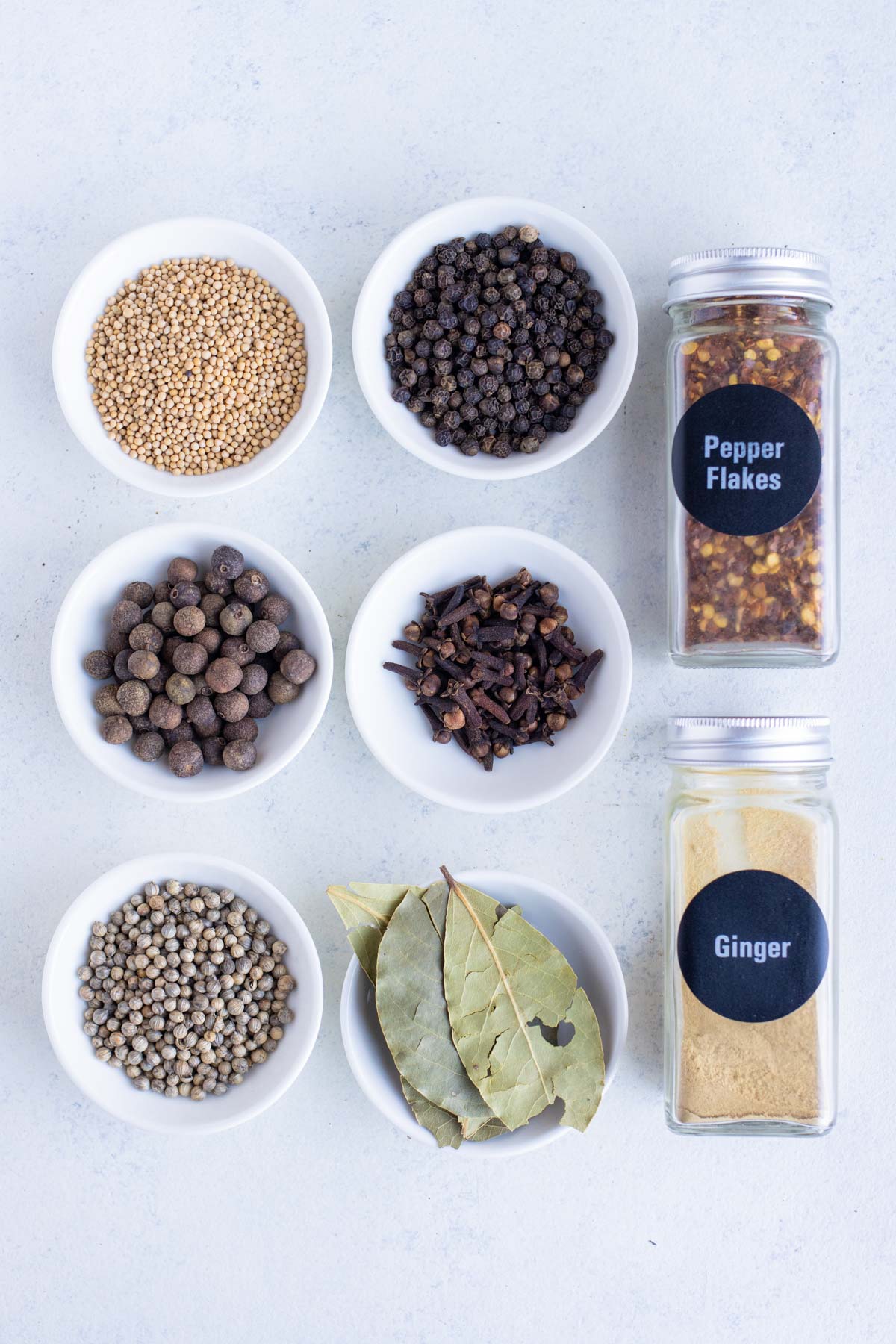 Black peppercorns, yellow mustard seeds. coriander seeds, bay leaves, red pepper flakes, whole cloves, ground ginger, allspice berries, and dill seed are the ingredients for this recipe.