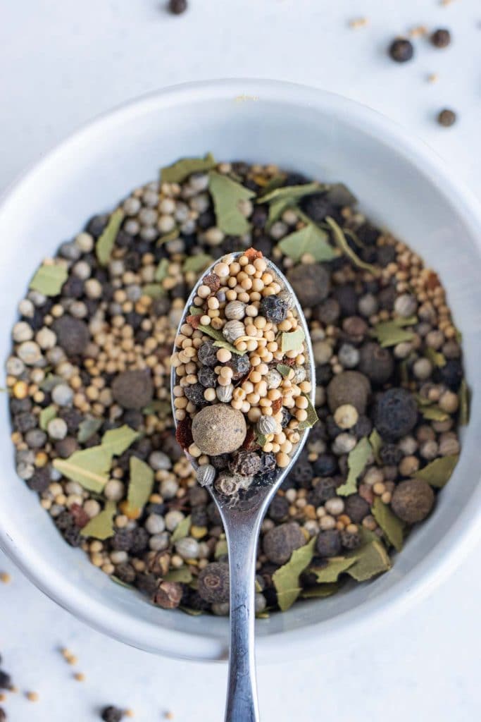 Pickling spice is shown on a bowl on the counter.