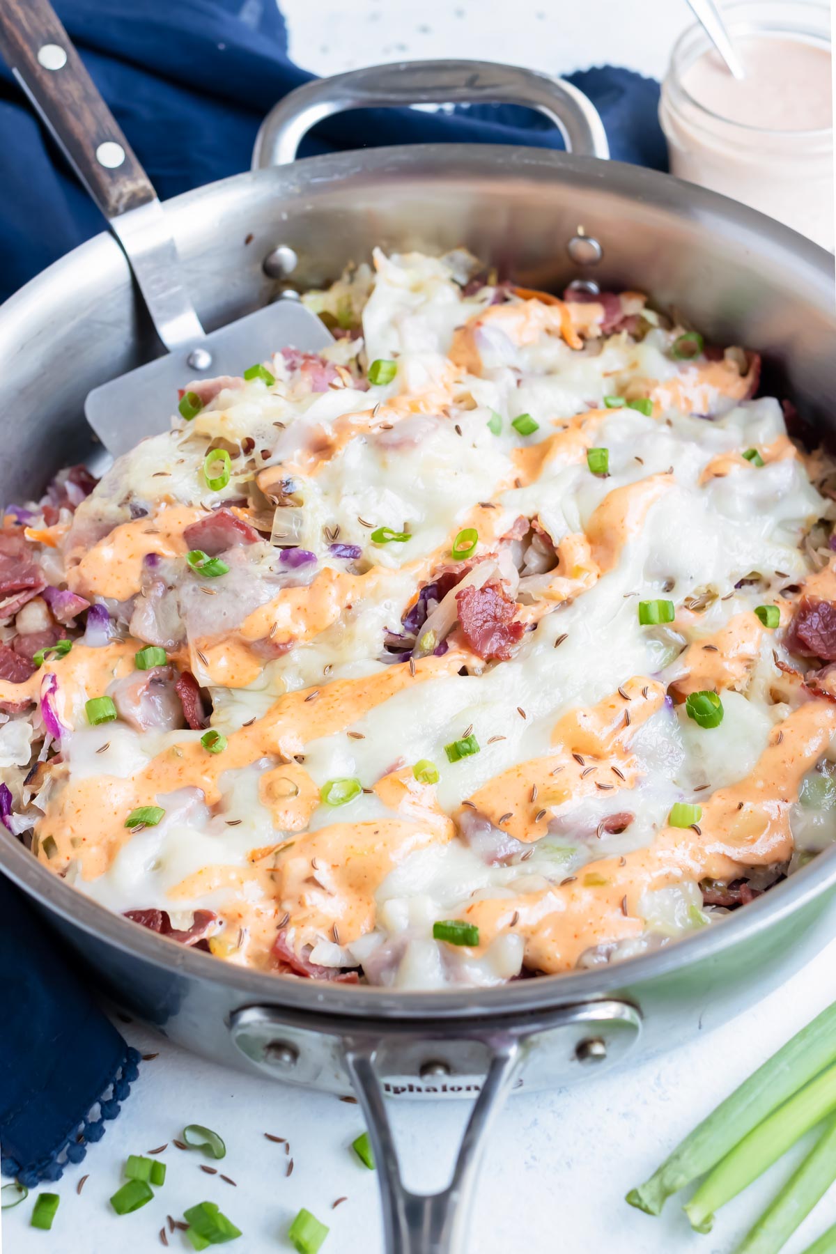 Reuben in a bowl is topped with homemade thousand island dressing.