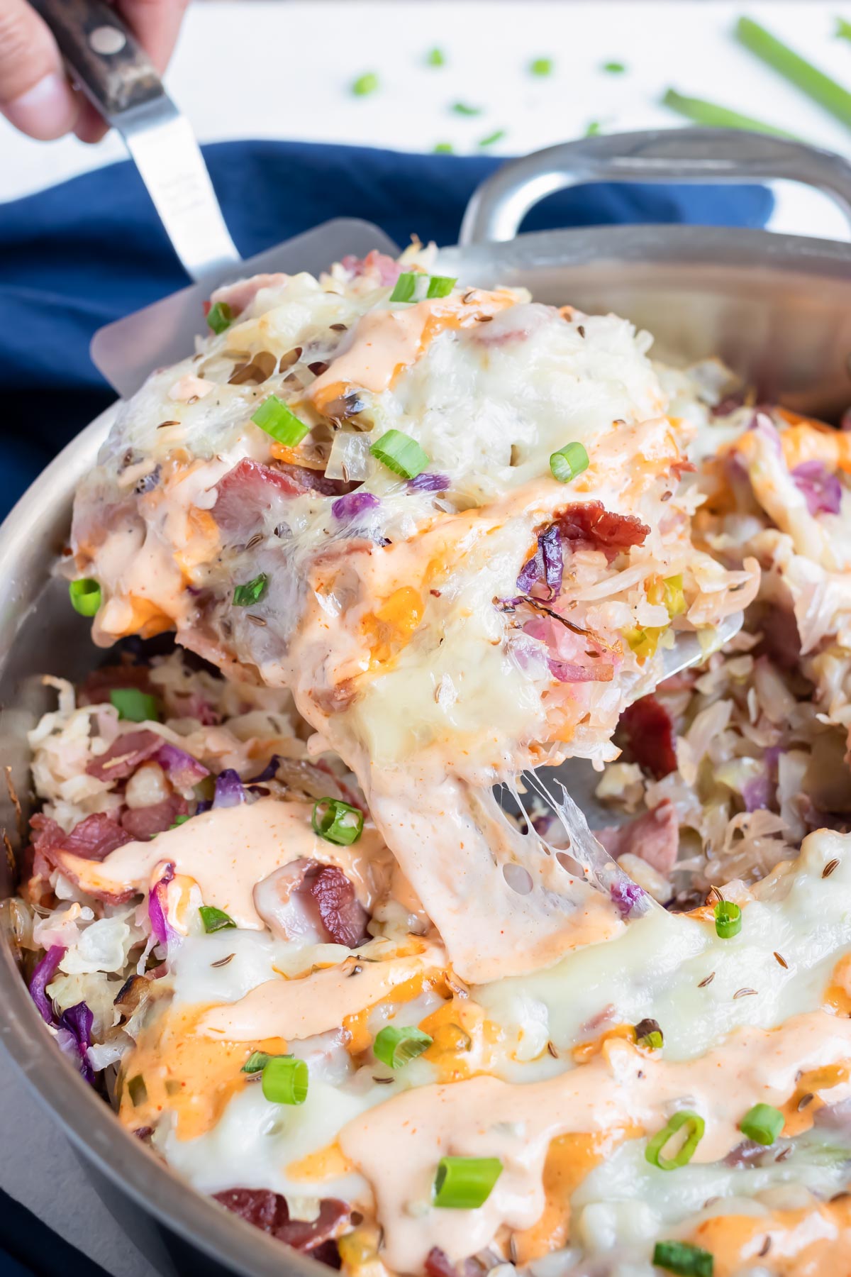 Cheesy, reuben in a bowl is served with a spatula.