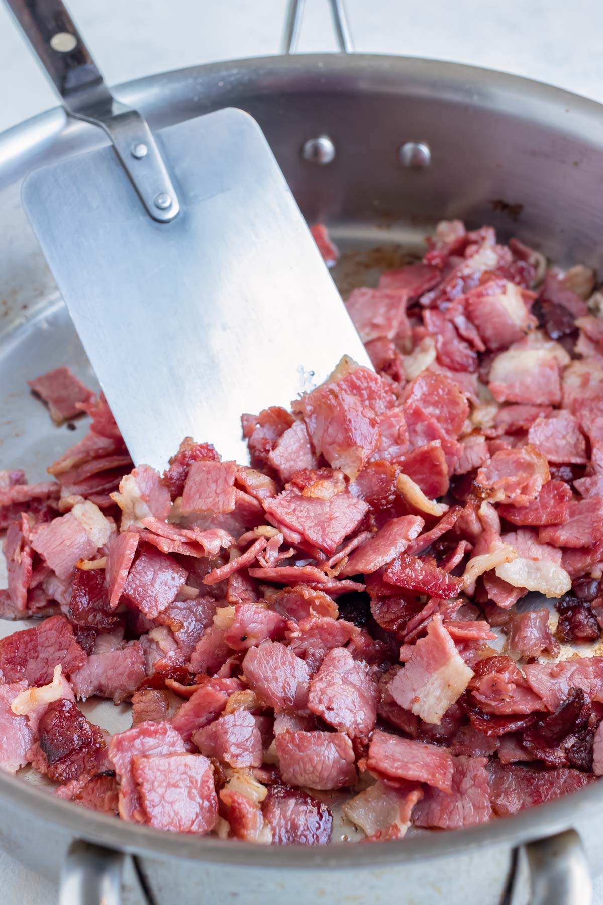 The corned beef is sautéed on the stove.